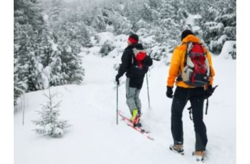 Image of 2 people skiing backpack