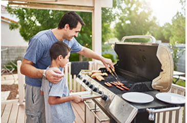 Image of Father teaching son to grill