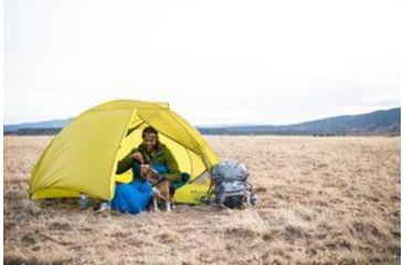 Image of Man and a dog camping in a yellow Marmot tent