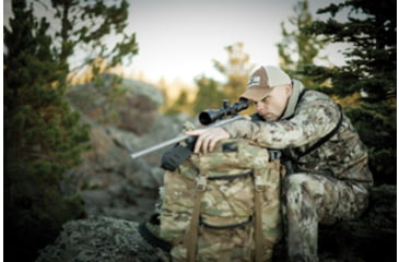 Image of Man Wearing Camo Hunting Clothes and a Vortex Hat Out in the Woods