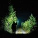 man using bright flashlight outdoors