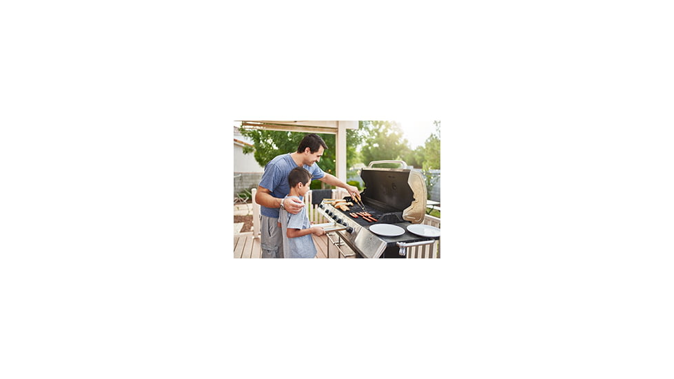 Father teaching son to grill