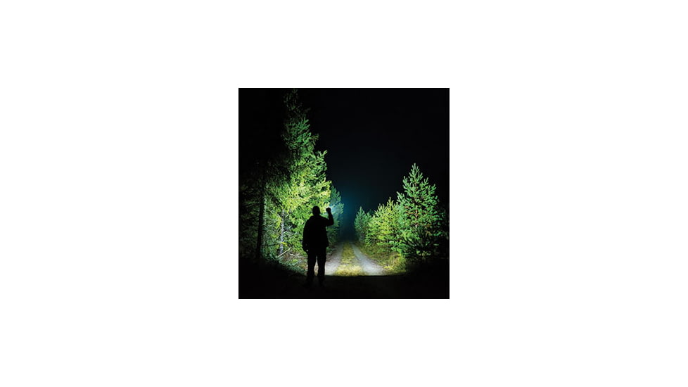 man using bright flashlight outdoors