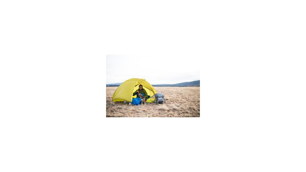 Man and a dog camping in a yellow Marmot tent