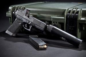 Pistol with a red dot sight and a silencer